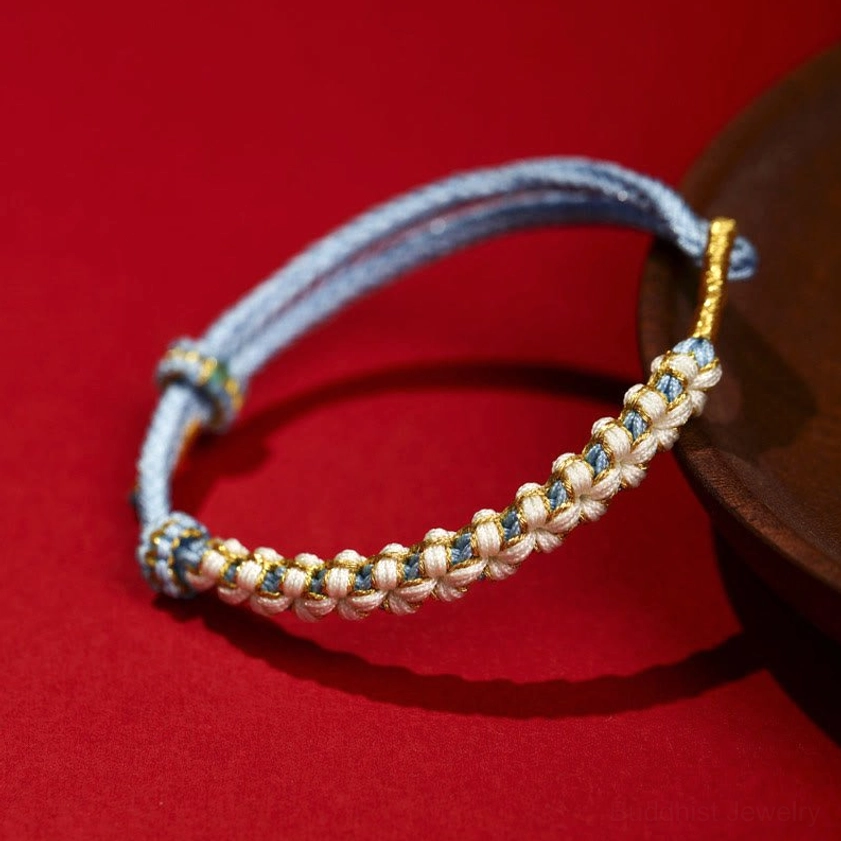 Blue Buddhist peach blossom knot bracelet handcrafted with gold thread for healing and spiritual balance