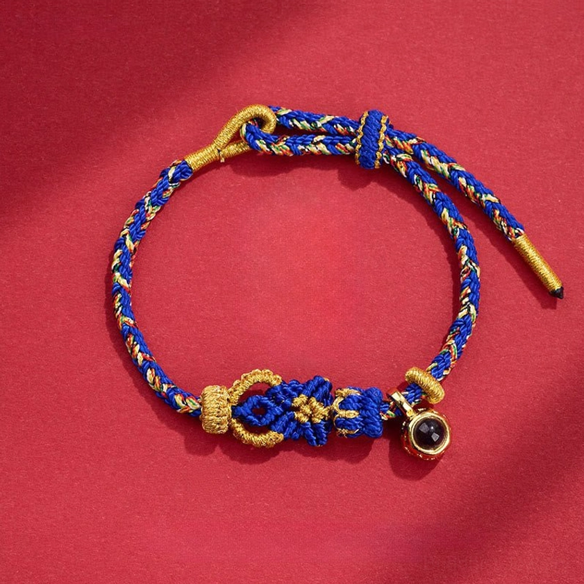 Blue Buddhist string bracelet with hand-woven Buddha knot decoration and copper bead accent