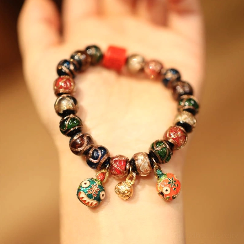 Blue God of Wealth Buddhist bracelet with red and blue colored beads and luck charm accents