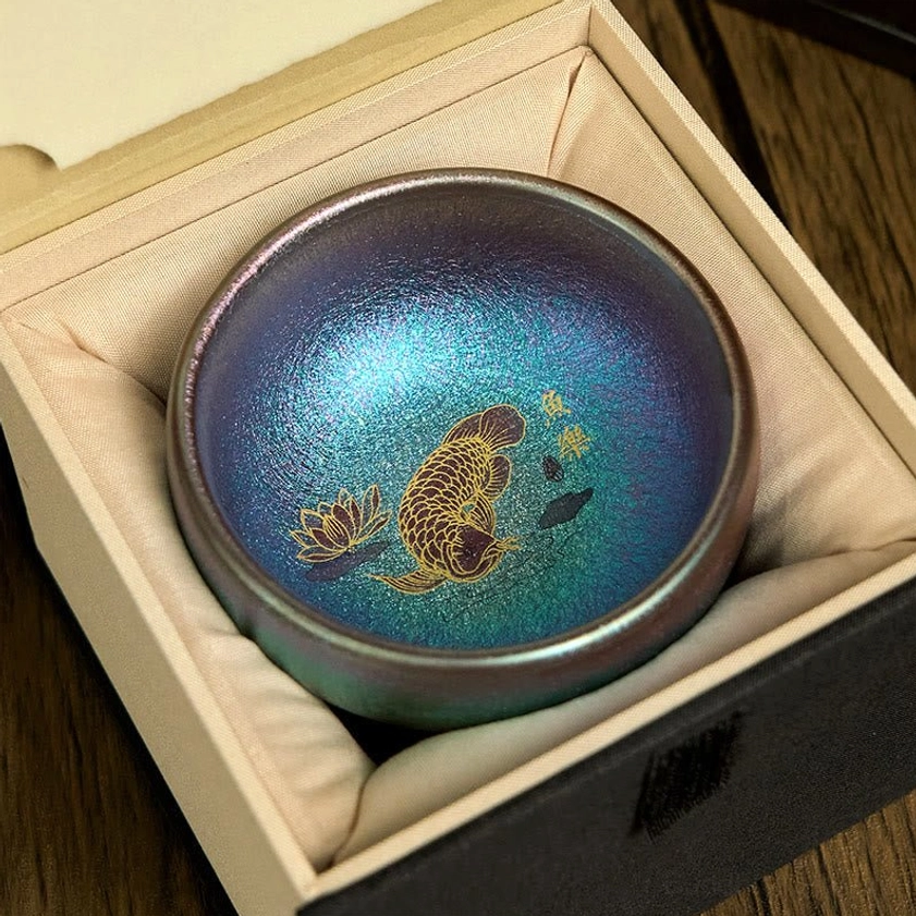 Blue gold koi fish Jianzhan tea cup with glaze detail and lotus leaf design close-up