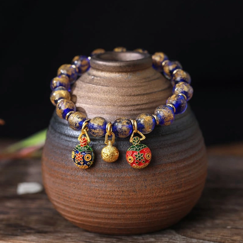 Blue-toned Liuli glass bead bracelet with gold swallowing beast Pixiu family charms - handmade Buddhist prosperity bracelet