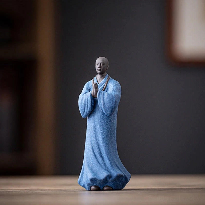 Blue handcrafted ceramic meditation monk figurine with detailed prayer beads and serene expression