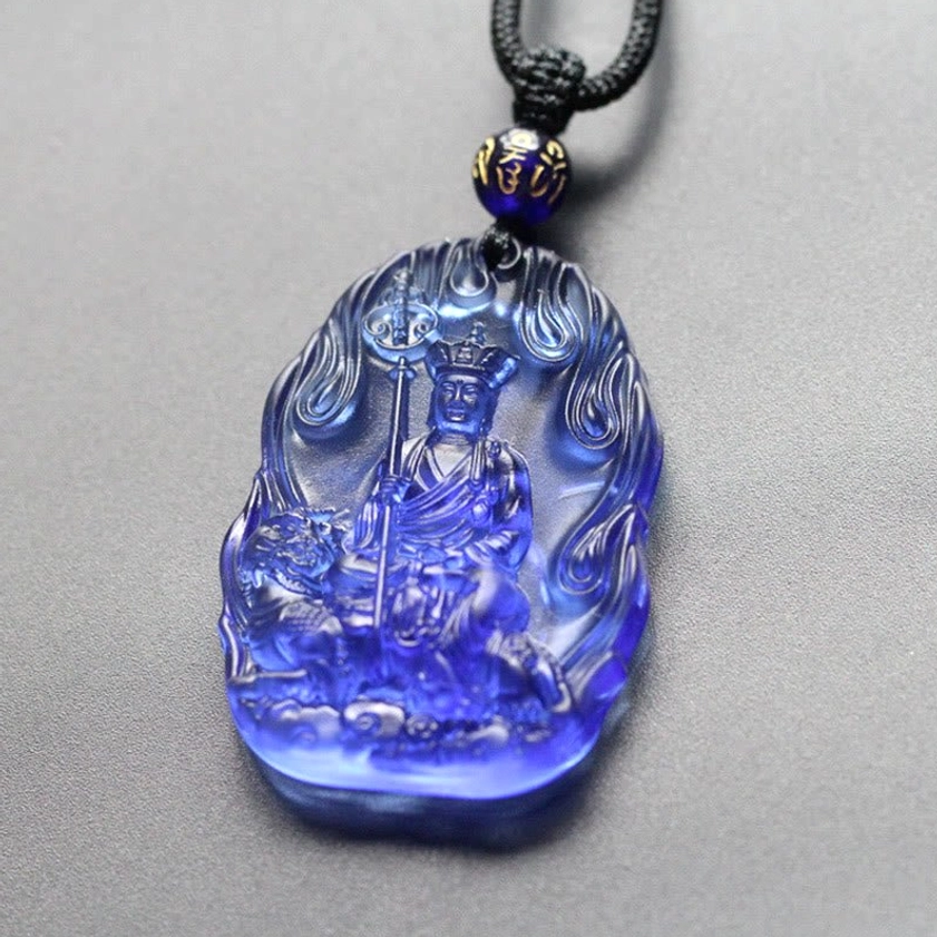 Deep blue Ksitigarbha Buddha Liuli crystal pendant necklace with embossed statue and flame relief border, studio view