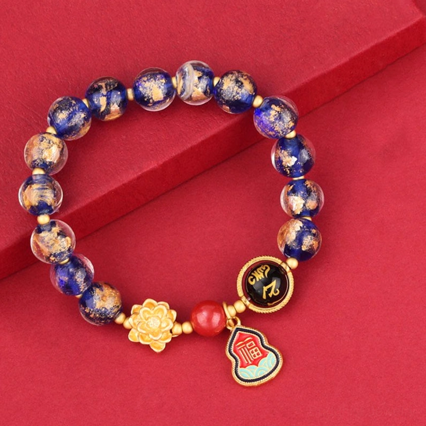 Blue incense ash glass bead bracelet featuring Om Mani Padme Hum charm, lotus symbol, and Sanskrit inscription bead