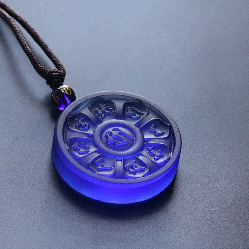 Translucent frosted blue Buddhist Liuli pendant with embossed sacred script three-quarter view