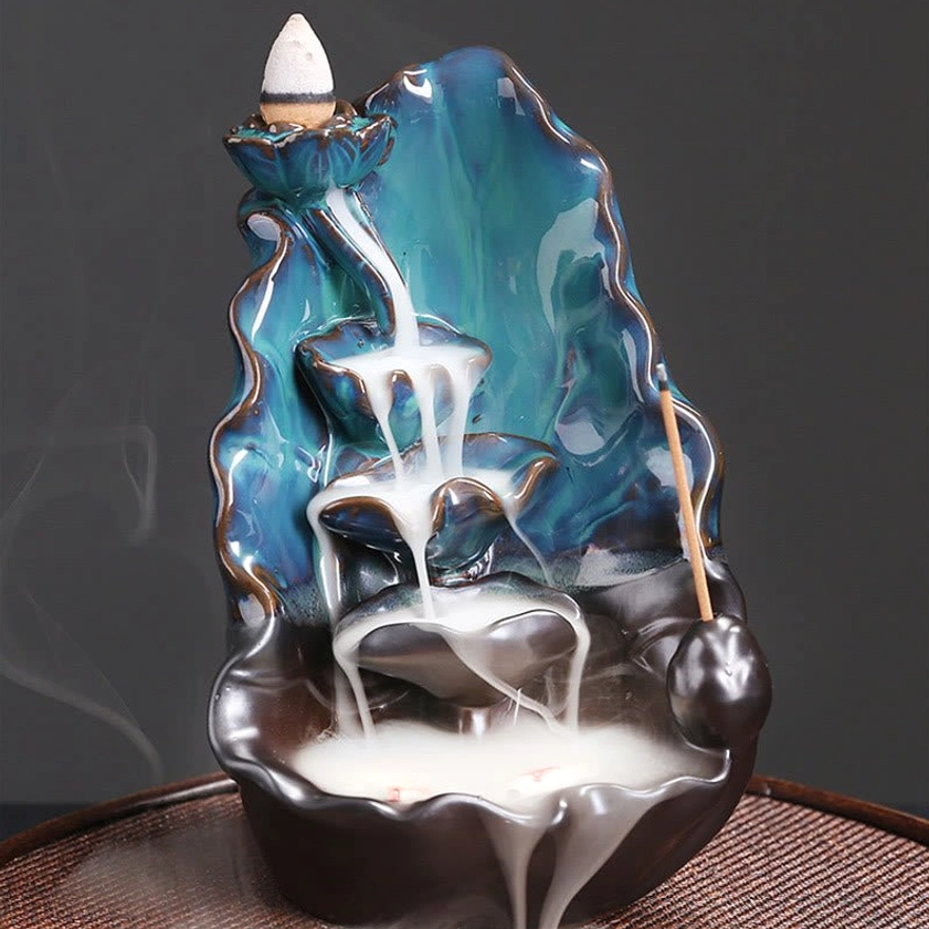 Direct front view of blue lotus backflow incense burner showing multi-layered smoke waterfall effect and incense stick mount