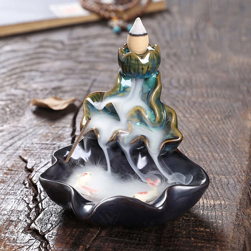 Blue lotus koi ceramic backflow incense burner with flowing smoke on wooden surface