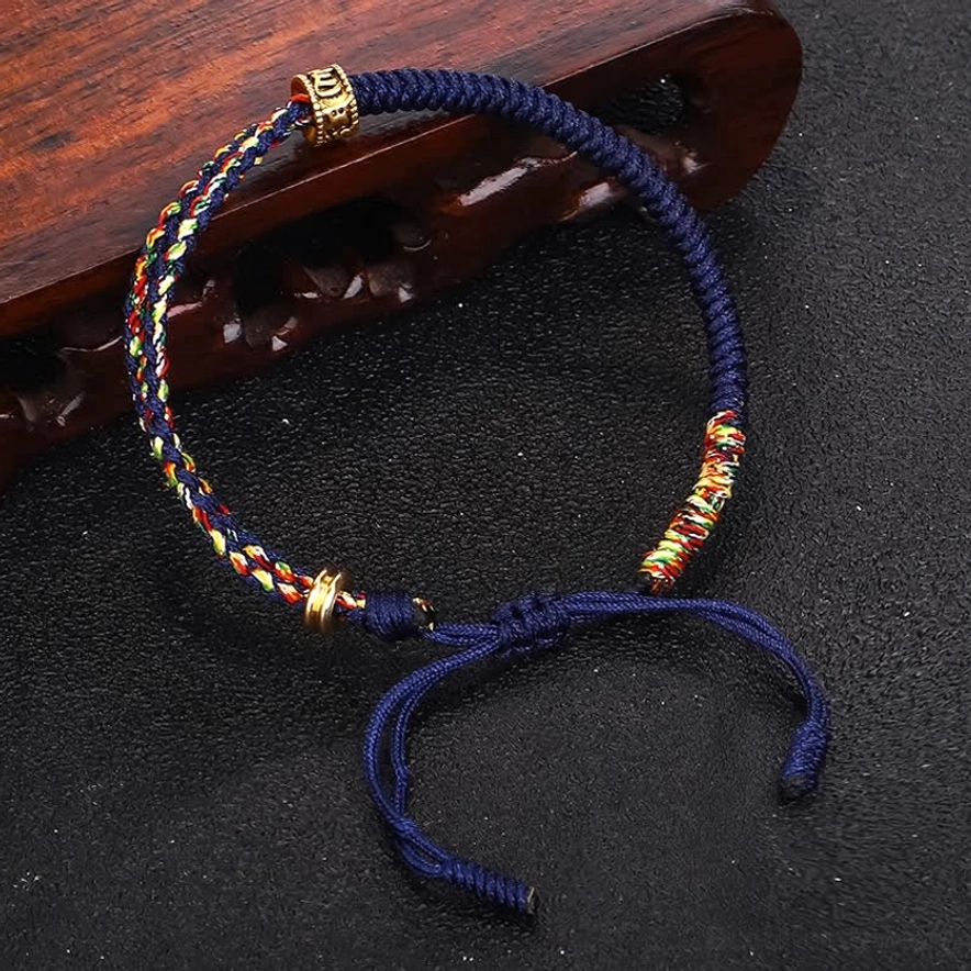 Blue Om Mani Padme Hum Buddhist protective string bracelet with copper mantra bead and multicolor woven segments top view