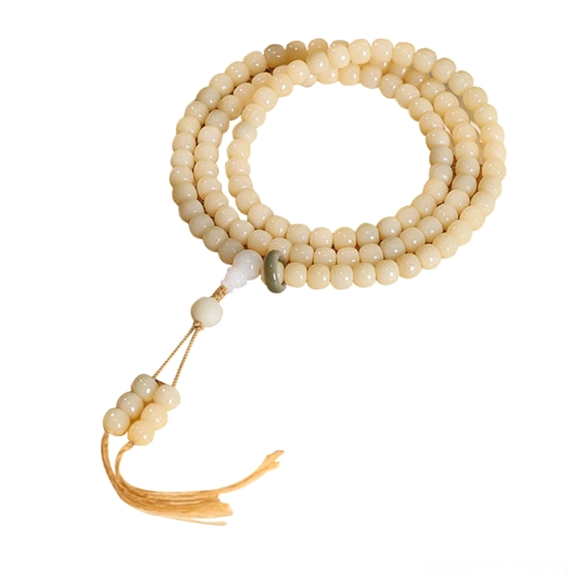 Loose bodhi seed prayer mala beads with tassel dangle and green accent bead, neutral background