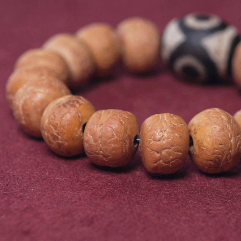 Textured bodhi seed beads with sacred dzi bead symbol close-up side view