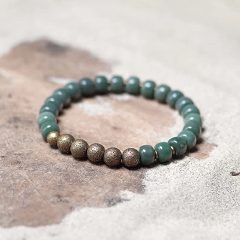 Bodhi seed copper bracelet flat lay showing round cyan beads with vintage bronze spacer accents