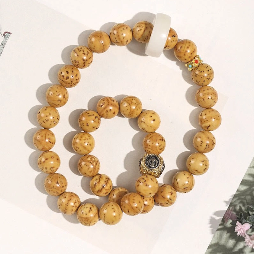 Tan double wrap bodhi bracelet with textured beads, engraved metal charm and gemstone decorations