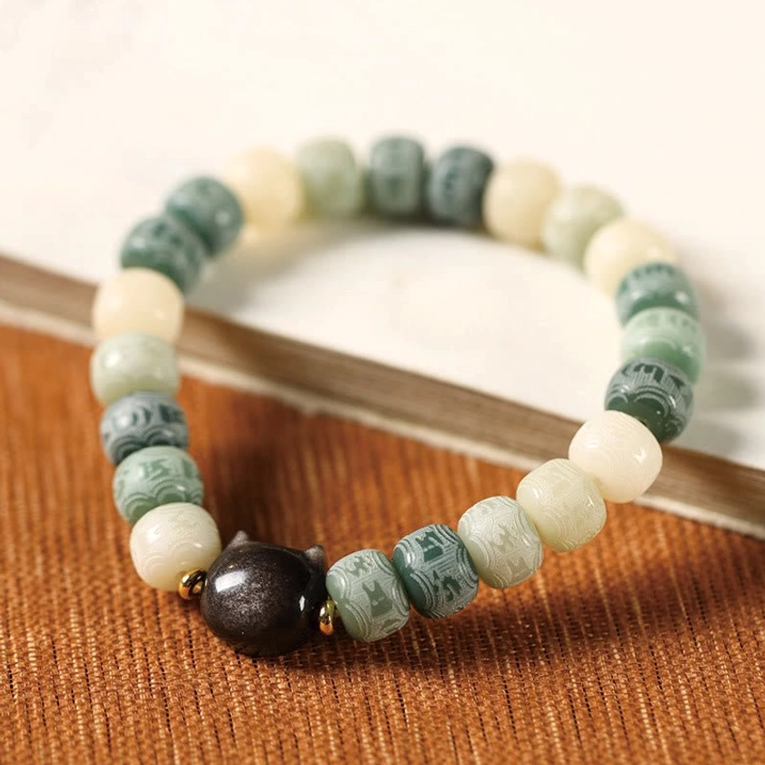 Bodhi seed bracelet showing texture and natural variations of carved spiritual beads and obsidian charm