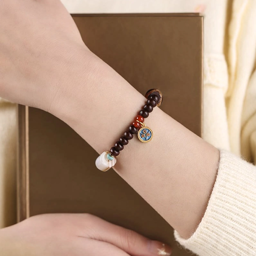 Woman wearing purple bodhi seed dzi bead bracelet as daily spiritual accessory with white sleeve