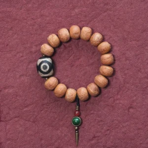 Bodhi seed and hand-painted dzi bead Buddhist mala bracelet with green copper pendant on dark red background