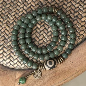 Bodhi seed and hand-painted dzi bead triple wrap bracelet with vintage bronze hardware, top-down flat lay view