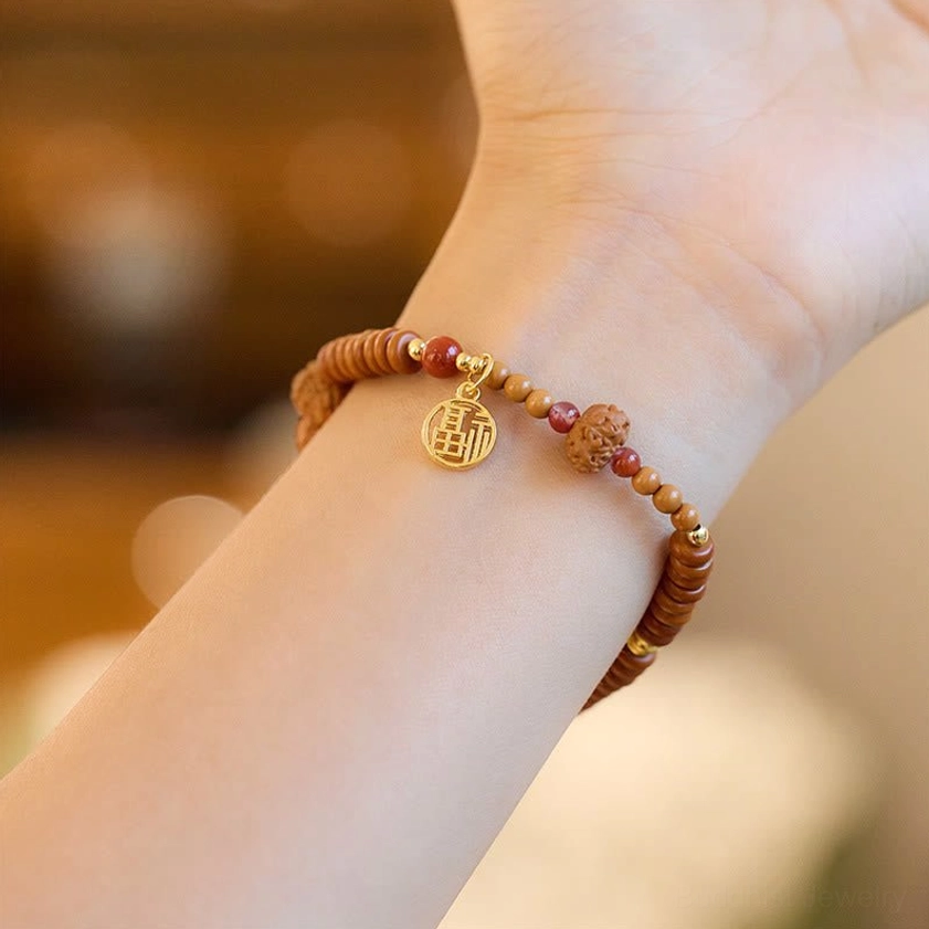 Single-layer Bodhi seed bracelet with black onyx bead and gold Fu character charm worn on wrist