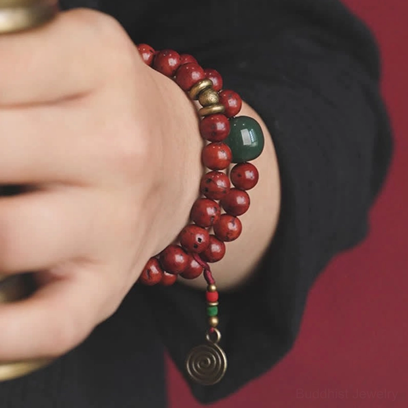 Close-up of handmade bodhi seed cyan jade bracelet on wrist showing brass details and green accent bead
