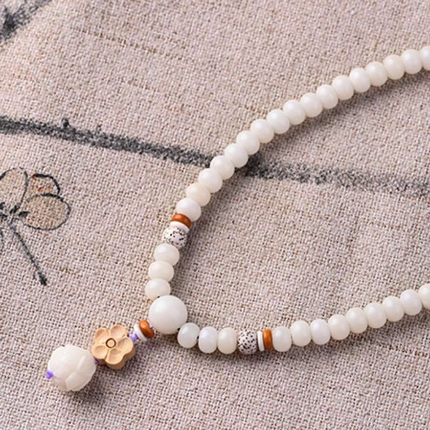 White jade bodhi lotus bracelet styled with complementary spiritual jewelry pieces