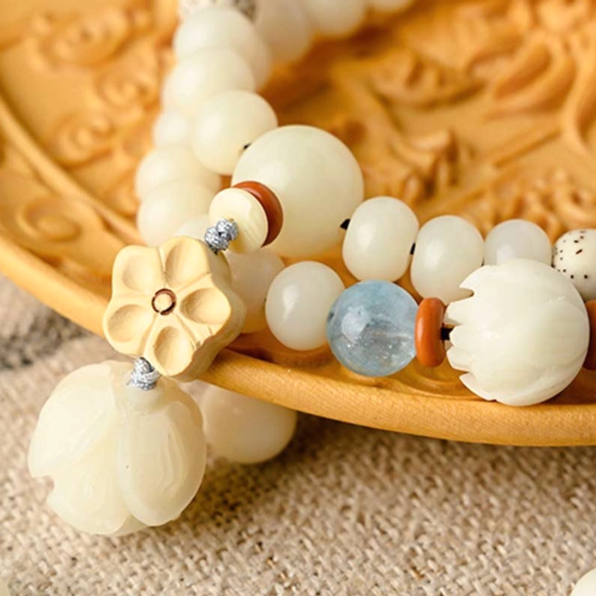 Close-up of handmade bodhi bracelet showing detailed lotus pendant and blue accent beads