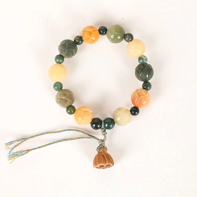 Full flat lay of bodhi seed lotus bracelet with smooth mixed stone beads and small braided tassel on dark background