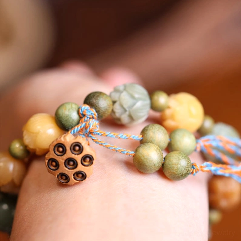 Bodhi seed lotus bracelet worn on wrist with carved lotus beads and detailed lotus charm on soft blurred background