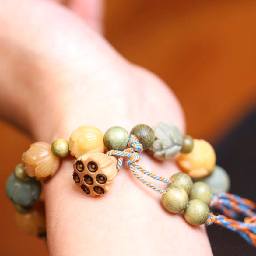Wearable bodhi seed bracelet worn on wrist with lotus pod charm and multicolor beads on warm wooden background
