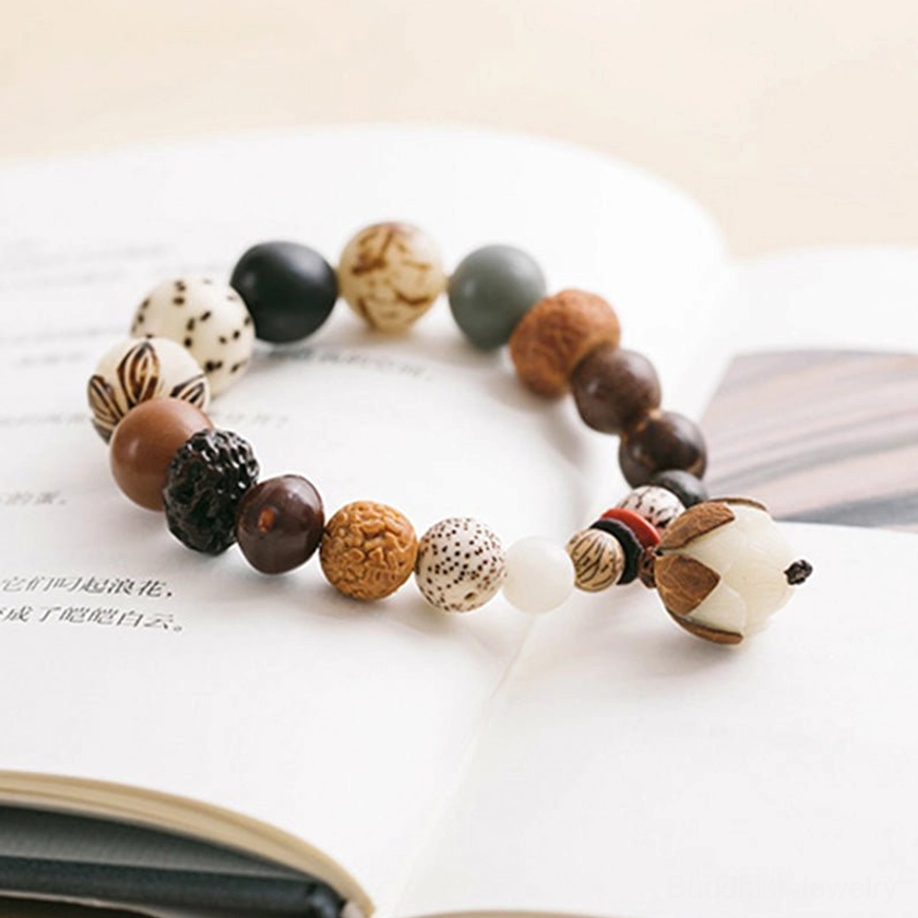 Bodhi seed lotus mala bracelet flat lay on antique book with earthy beads