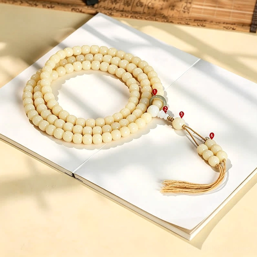 108 bead bodhi seed prayer mala with braided tassel and decorative beads, top-down view on white background