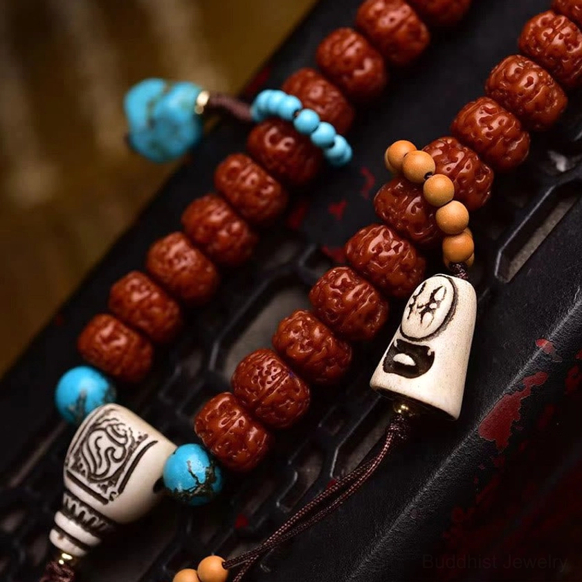Close-up side view of carved ridged bodhi seed beads with bone-style guru beads and copper connectors on dark leather