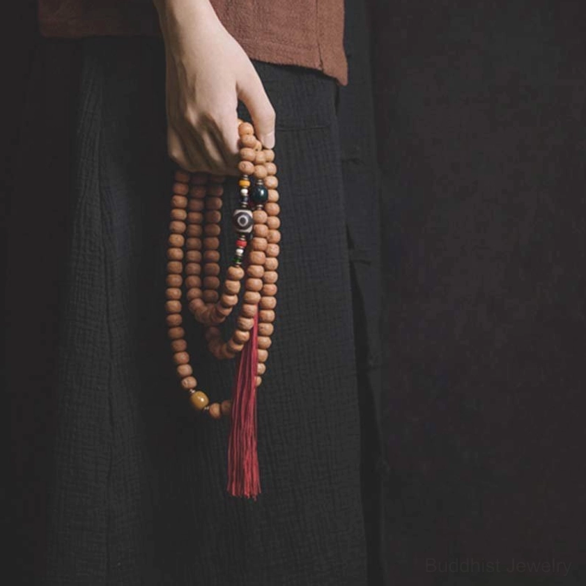 Bodhi seed mala necklace front view showing prayer beads with Dzi bead detail and red tassel pendant