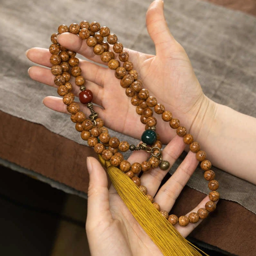 Bodhi seed 108 mala beads held in hands showing natural bead texture and spiritual jewelry details