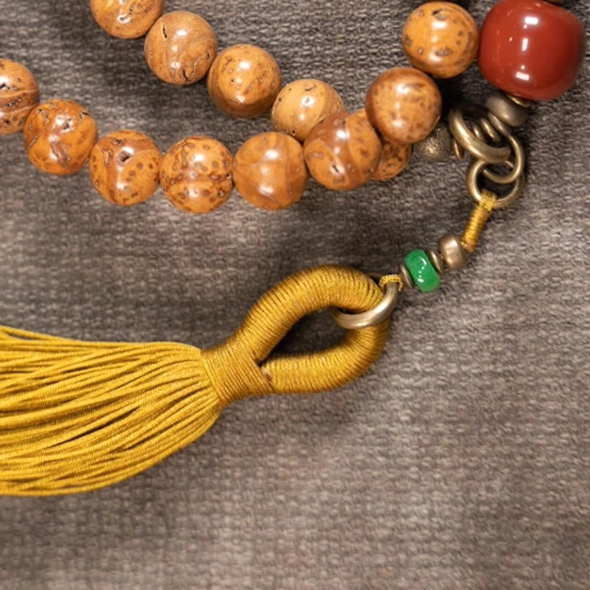 Buddhist mala beads accessories detail including yellow tassel metal clasp and accent beads