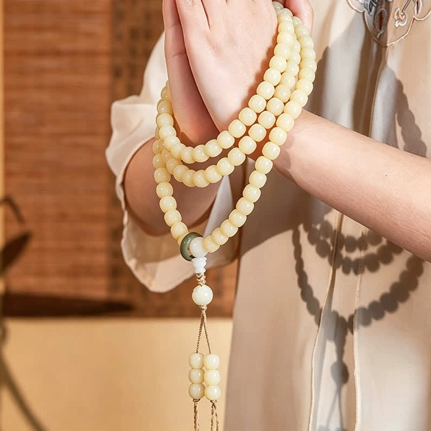 Bodhi seed mala bracelet worn draped on both arms, showing authentic wearing style indoors