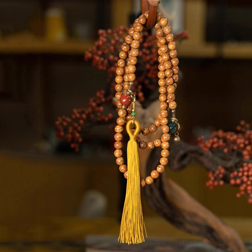 Long bodhi seed mala prayer beads necklace with yellow tassel and natural stone accents hanging