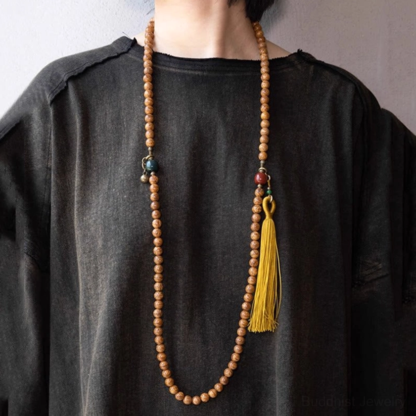 Bodhi seed mala necklace worn on body with yellow tassel and multicolor stone accents
