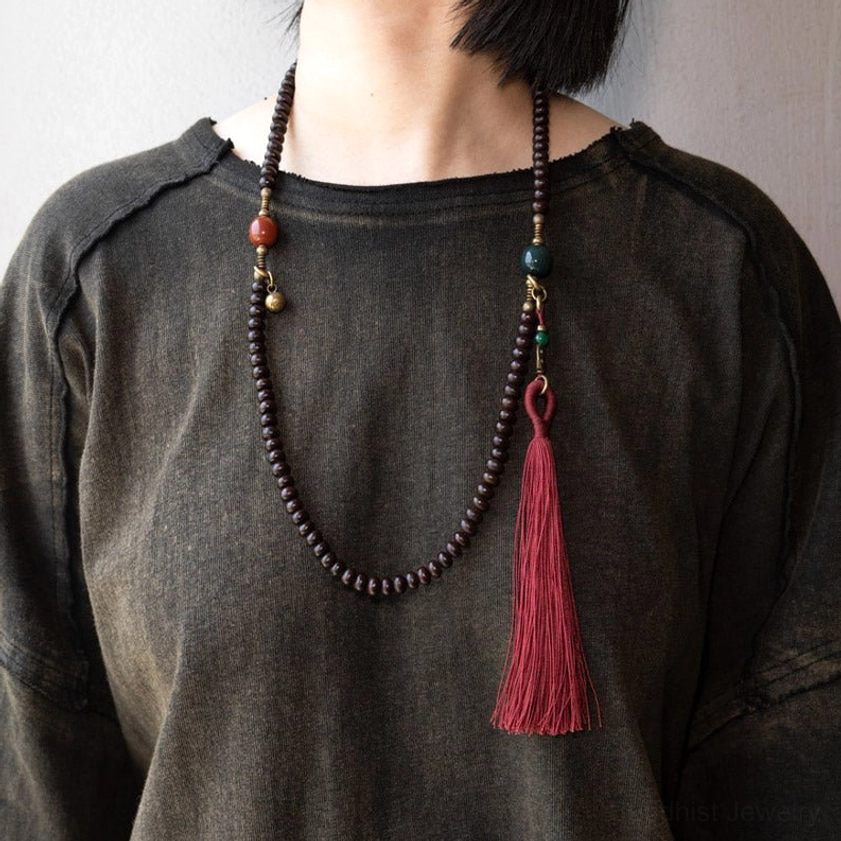 108 Mala Prayer Beads worn as necklace on neck showing dark brown bodhi seeds, red tassel, and vintage style details