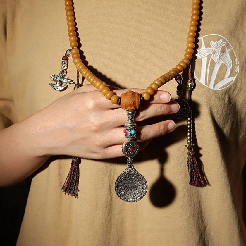 Woman Wearing Bodhi Seed Mala Prayer Necklace with Silver Pendants and Tassel Accents