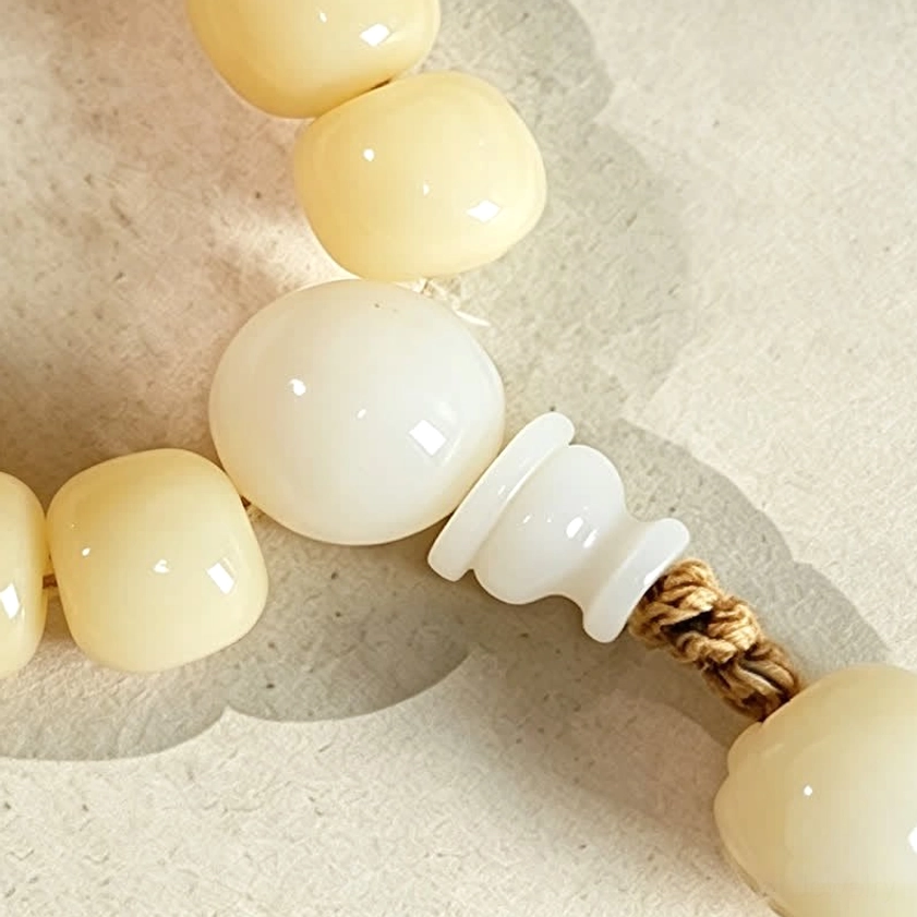Hand-polished bodhi seed prayer mala with lotus accent pendant, showing craftsmanship and natural variations