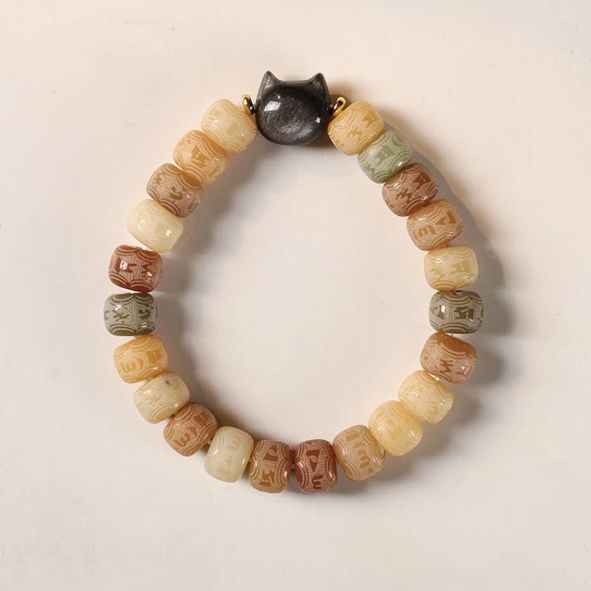 Flat lay top view of multicolor bodhi seed bracelet featuring Om Mani Padme Hum carved beads and black cat head bead accent