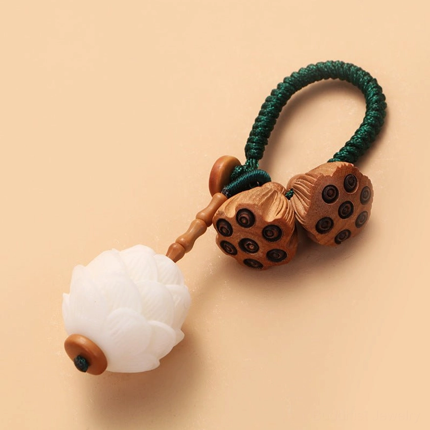 Handcrafted peach wood bodhi keychain with white lotus charm and natural materials detail