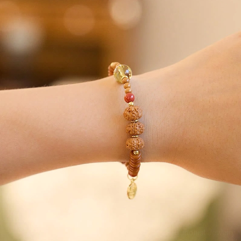 Bodhi seed prayer bracelet with clear glass bead and small drop charm worn on wrist