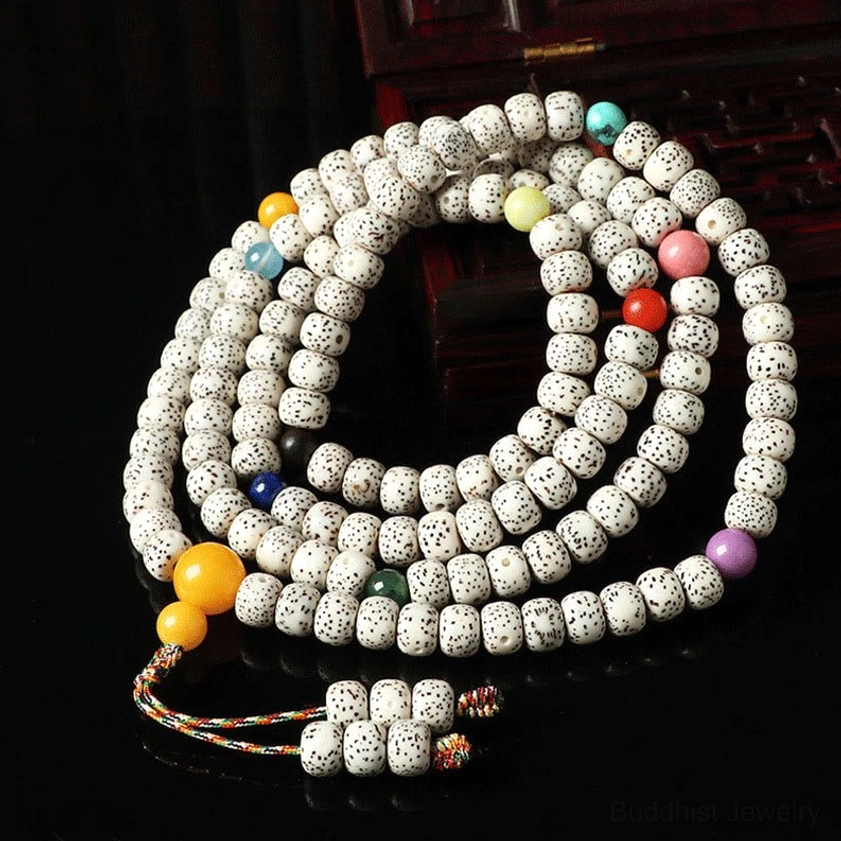 Mixed color bodhi seed mala bracelets with glass beads and colorful braided tassel pendant on dark background