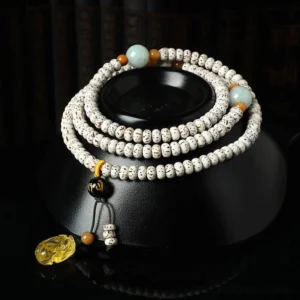 Bodhi seed mala bracelet with amber agate pendant displayed on black ceramic stand, showing side and top-down view