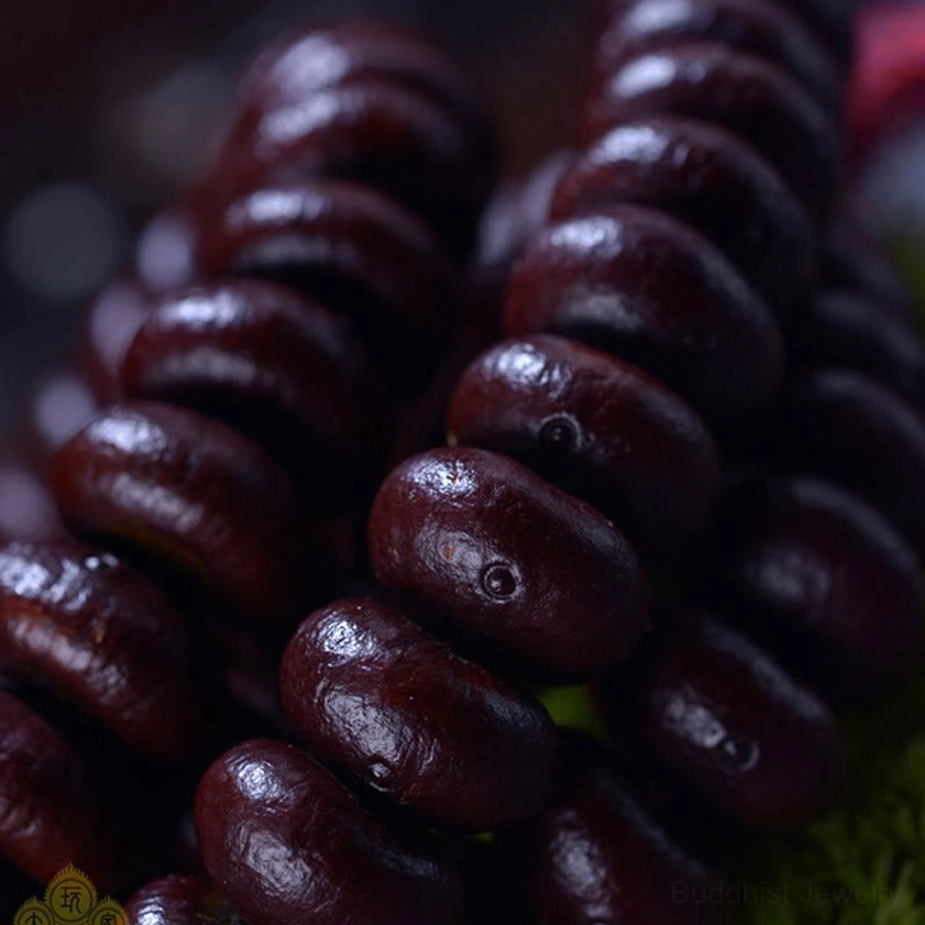 Extreme close-up of purple bodhi seed beads showing individual lotus-seat marking and natural texture