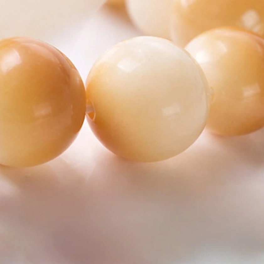 Close-up macro view of polished white bodhi seed beads with smooth glossy texture and natural grain