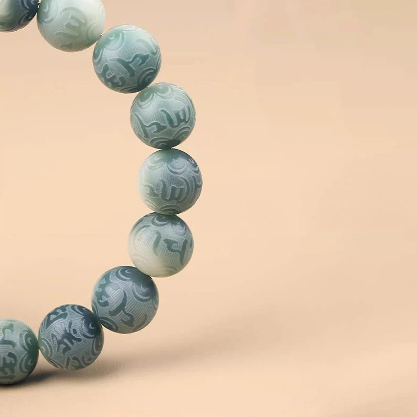 Close-up detail of engraved bodhi seed beads with Om Mani Padme Hum sacred mantra text