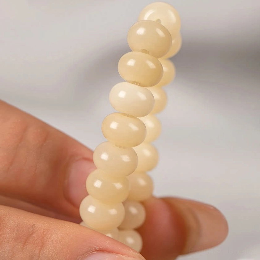 Macro close-up detail of matte off-white Bodhi seed barrel beads showing natural texture and finish