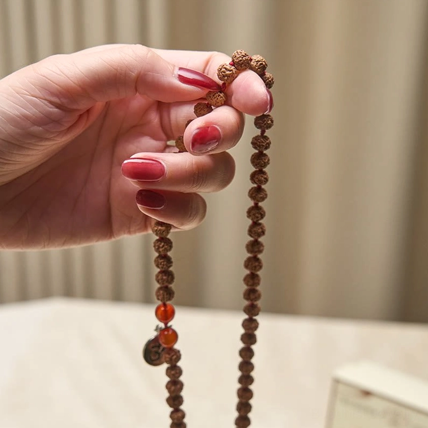 Authentic bodhi seed beads hand-held close-up highlighting natural speckled texture of enlightened seeds