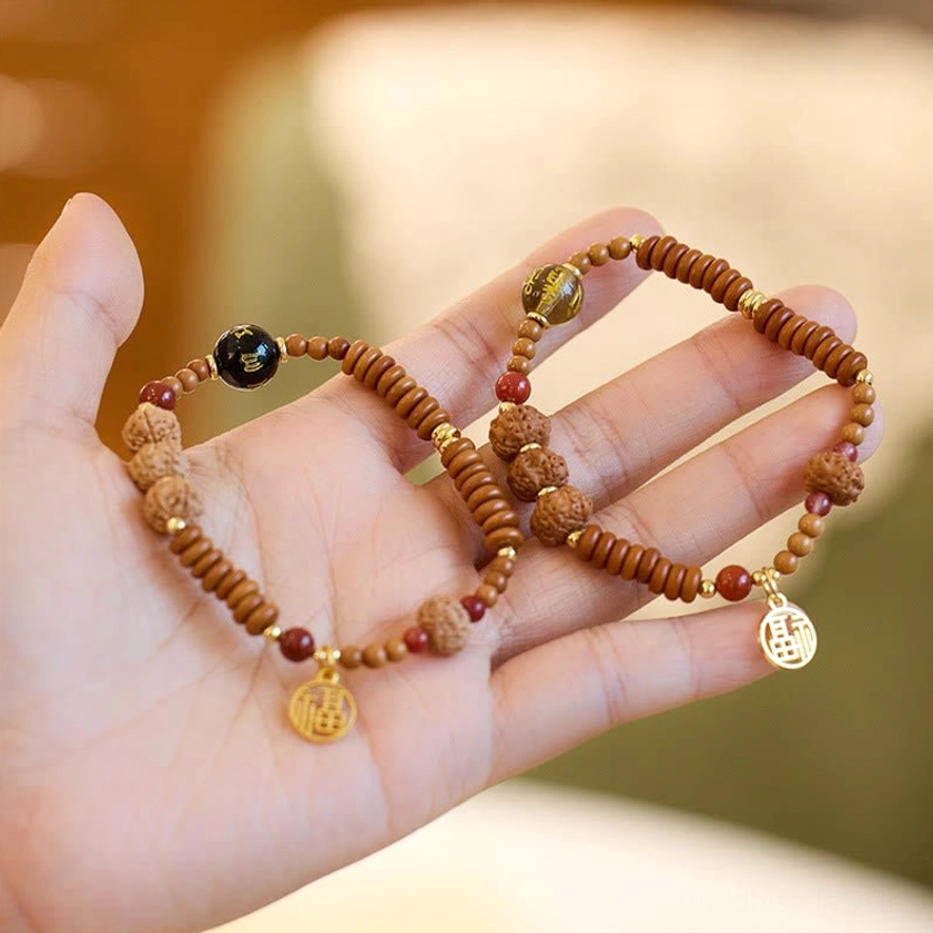 Handmade Bodhi seed black onyx smoky quartz Buddhist wealth bracelet with gold Fu charm displayed in palm
